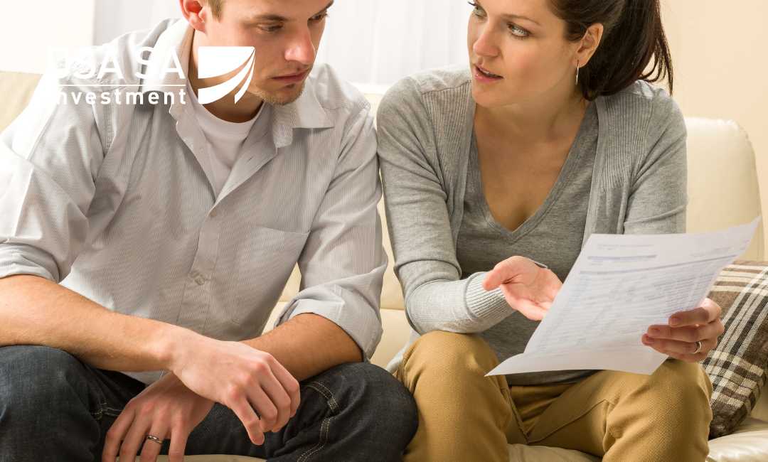A man and woman on a sofa review a document together, with a USA Investment logo overlay.