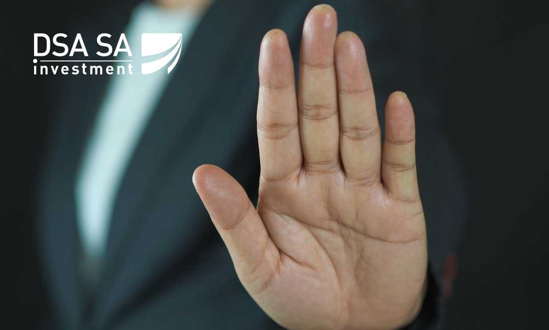 Open hand raised in a stop gesture in front of a dark background with the DSA SA Investment logo in the top-left corner.